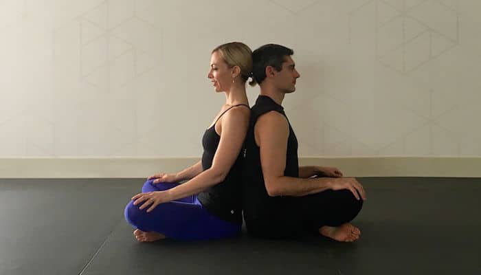 Posturas de sentado giro espinal de yoga en pareja